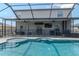 Swimming pool with integrated jacuzzi, bar seating, safety fence and screen enclosure at 6653 Mineral Springs Rd, New Port Richey, FL 34653