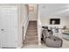 Carpeted staircase leading to the second floor, adjacent to a cozy living area with comfortable seating at 6653 Mineral Springs Rd, New Port Richey, FL 34653