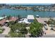 Aerial view of a waterfront property with a pool, dock, and lush landscaping at 860 Harbor Is, Clearwater Beach, FL 33767