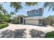 Charming exterior view of a two-story home with a large driveway and mature landscaping at 860 Harbor Is, Clearwater Beach, FL 33767