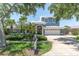 Beautiful two-story home featuring a well-manicured lawn, palm trees, and a two-car garage at 860 Harbor Is, Clearwater Beach, FL 33767