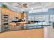 Well-equipped kitchen with wood cabinets, black countertops, and a unique curved glass island at 860 Harbor Is, Clearwater Beach, FL 33767