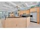 Bright and spacious kitchen with wood cabinetry, a large island, and stainless steel appliances at 860 Harbor Is, Clearwater Beach, FL 33767