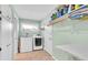 Functional laundry room with a washer, dryer, storage shelves, and a folding table at 860 Harbor Is, Clearwater Beach, FL 33767