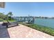 Brick patio with lounge chairs overlooking the water and private dock, perfect for relaxing and enjoying the view at 860 Harbor Is, Clearwater Beach, FL 33767