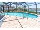Waterfront pool featuring brick pavers and metal railings surrounded by a screened enclosure at 860 Harbor Is, Clearwater Beach, FL 33767