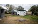 Backyard featuring a shed, a detached garage, and a fire pit at 8742 Narcissus Ave, Seminole, FL 33777