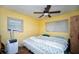 Bright bedroom with two windows, ceiling fan and a comfortable bed with a patterned quilt at 8742 Narcissus Ave, Seminole, FL 33777