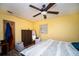 Cozy bedroom with wood-look floors, ceiling fan, and a comfortable bed with a decorative quilt at 8742 Narcissus Ave, Seminole, FL 33777