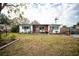 Inviting single-story home featuring brick accents and a cozy seating area on the front porch at 8742 Narcissus Ave, Seminole, FL 33777