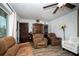 Comfortable living room with wood-look floors, plush seating, and a decorative ceiling fan at 8742 Narcissus Ave, Seminole, FL 33777