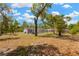 A sprawling backyard with mature trees, a flower bed, and an enclosed patio offering a serene outdoor space at 9013 Nakoma Way, Weeki Wachee, FL 34613