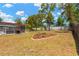 A spacious, grassy backyard featuring a flower bed and an enclosed patio with a grill, perfect for outdoor gatherings at 9013 Nakoma Way, Weeki Wachee, FL 34613
