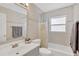 Bright bathroom featuring a bathtub and shower, a large mirror, and modern fixtures at 9013 Nakoma Way, Weeki Wachee, FL 34613