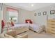 Comfortable bedroom with two twin beds, carpet flooring, and lots of natural light from the window at 9013 Nakoma Way, Weeki Wachee, FL 34613