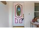 Close-up of a decorative front door with an oval window and pink trim, offering a warm welcome at 9013 Nakoma Way, Weeki Wachee, FL 34613