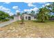 Charming single-story home featuring a well-maintained lawn, complemented by a palm tree and blue skies at 9013 Nakoma Way, Weeki Wachee, FL 34613