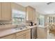 Bright kitchen with stainless steel dishwasher and light wood cabinetry, and a double sink under the window at 9013 Nakoma Way, Weeki Wachee, FL 34613