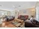 Spacious living room featuring a leather sofa set, hardwood floors and an adjacent dining area at 9013 Nakoma Way, Weeki Wachee, FL 34613