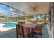 A covered patio area with a dining set and lounge chairs, ideal for relaxing and enjoying the outdoors at 9013 Nakoma Way, Weeki Wachee, FL 34613