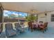 Enclosed patio featuring a dining set, ceiling fan, and a pair of comfortable lounge chairs perfect for entertaining at 9013 Nakoma Way, Weeki Wachee, FL 34613