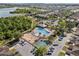 An aerial shot showcasing a community pool, playground, lush greenery, and a serene lake at 9031 Sienna Moss Ln, Riverview, FL 33578