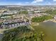 A picturesque aerial view showing a vibrant neighborhood nestled amongst green trees and serene lakes under a partly cloudy sky at 9031 Sienna Moss Ln, Riverview, FL 33578