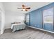 Bright bedroom with ceiling fan, blue accent wall and multiple windows for natural light at 9031 Sienna Moss Ln, Riverview, FL 33578