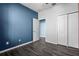 Bedroom features wood style floors, blue accent wall, and closet storage at 9031 Sienna Moss Ln, Riverview, FL 33578