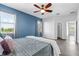 Comfortable bedroom featuring a ceiling fan, two windows and calming blue accent wall at 9031 Sienna Moss Ln, Riverview, FL 33578