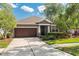 Charming single-story home with a well-manicured lawn, mature trees, and a two-car garage at 9031 Sienna Moss Ln, Riverview, FL 33578