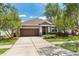 Charming single-story home with a well-manicured lawn, a wide driveway, and a cozy covered entryway at 9031 Sienna Moss Ln, Riverview, FL 33578