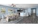 Open-concept living space with dining area, kitchen with breakfast bar, and sleek gray wood flooring at 9031 Sienna Moss Ln, Riverview, FL 33578