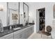 A modern bathroom is designed with dual sinks, gray cabinetry and stylish fixtures and opens to a walk-in closet at 916 Seagrape Dr, Ruskin, FL 33570
