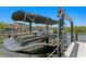 This waterfront property features a covered boat on a lift, providing easy access to the water for boating enthusiasts at 916 Seagrape Dr, Ruskin, FL 33570