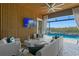Stylish lanai with outdoor seating, ceiling fan, TV, and view of the pool and waterfront at 916 Seagrape Dr, Ruskin, FL 33570