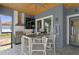 Well-equipped outdoor kitchen with stainless steel grill, bar seating, and modern finishes at 916 Seagrape Dr, Ruskin, FL 33570