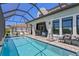 Gorgeous outdoor pool with seating, a shower, and lush landscaping, set within a screened enclosure at 916 Seagrape Dr, Ruskin, FL 33570