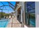 Outdoor shower with view of covered outdoor kitchen and screened pool at 916 Seagrape Dr, Ruskin, FL 33570