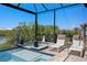 Relaxing screened pool area featuring lounge chairs, a hot tub, and serene views of the lush, natural surroundings at 916 Seagrape Dr, Ruskin, FL 33570