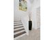Bright staircase with white railings, dark wood treads, and colorful art at 916 Seagrape Dr, Ruskin, FL 33570