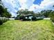 Expansive backyard featuring lush lawn, mature trees, and a verdant landscape, perfect for outdoor relaxation and entertainment at 924 Highview Dr, Palm Harbor, FL 34683