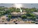 Aerial view of a low-rise building with lush landscaping and waterfront access at 950 Broadway # 103, Dunedin, FL 34698