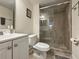 Bathroom featuring a glass-enclosed shower, vanity and commode at 950 Broadway # 103, Dunedin, FL 34698