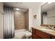 Bright bathroom featuring a shower-tub combo with tile surround and vanity with granite countertop at 950 Broadway # 103, Dunedin, FL 34698
