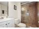 Bathroom featuring a glass-enclosed shower, vanity and commode at 950 Broadway # 103, Dunedin, FL 34698