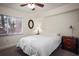 Bedroom featuring ceiling fan, large window, and classic bedside dresser at 950 Broadway # 103, Dunedin, FL 34698