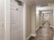 Well-lit hallway featuring neutral tones and tiled floors leads to the unit's entrance door at 950 Broadway # 103, Dunedin, FL 34698