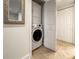 Convenient interior laundry closet with stacked washer and dryer units, and a tile floor at 950 Broadway # 103, Dunedin, FL 34698