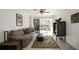 Comfortable living room with neutral tones, ceiling fan and sliding glass door to outdoor seating at 950 Broadway # 103, Dunedin, FL 34698